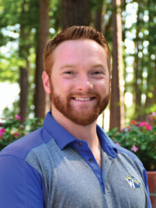 man with red hair in blue shirt, college staff member