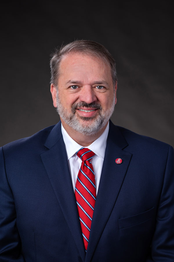 White Male wearing navy suit, Tim-Channell