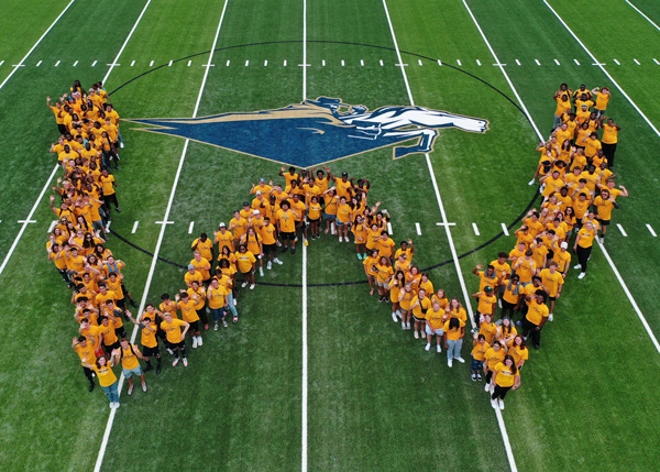 students forming large W on football field