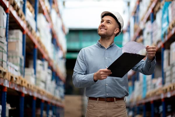 supply chain management man holding clipboard in warehouse