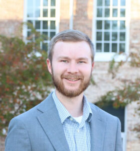 male student in front of brick building