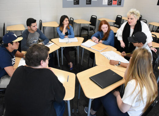 students around classroom tables with professor