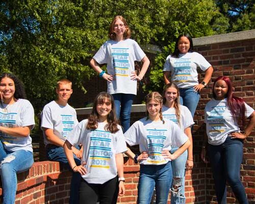 group of students next to brick wall