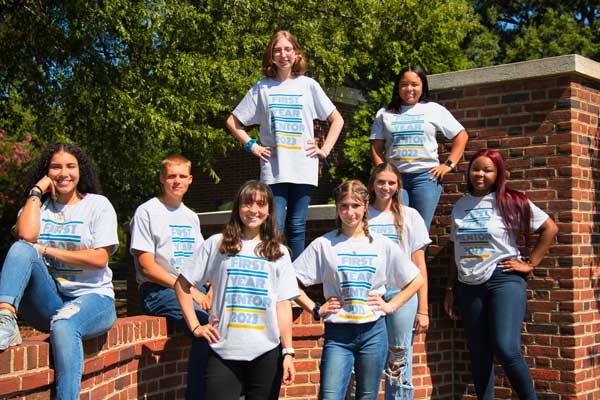 group of students next to brick wall