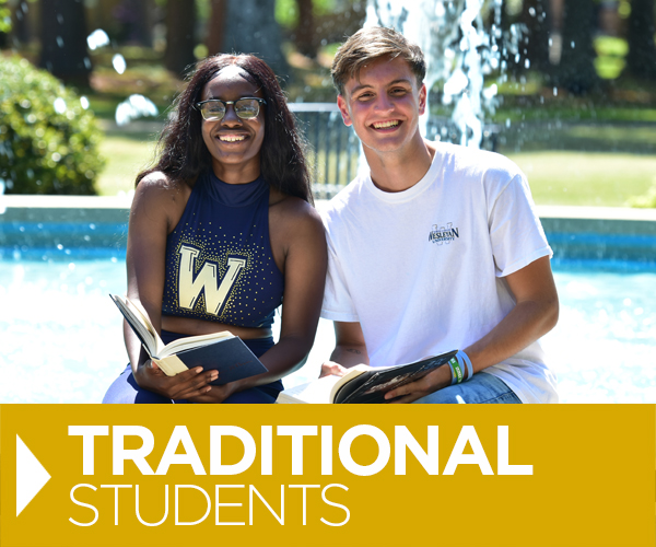 white male student and black female student in front of fountain