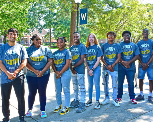 group of students standing in front of light pole