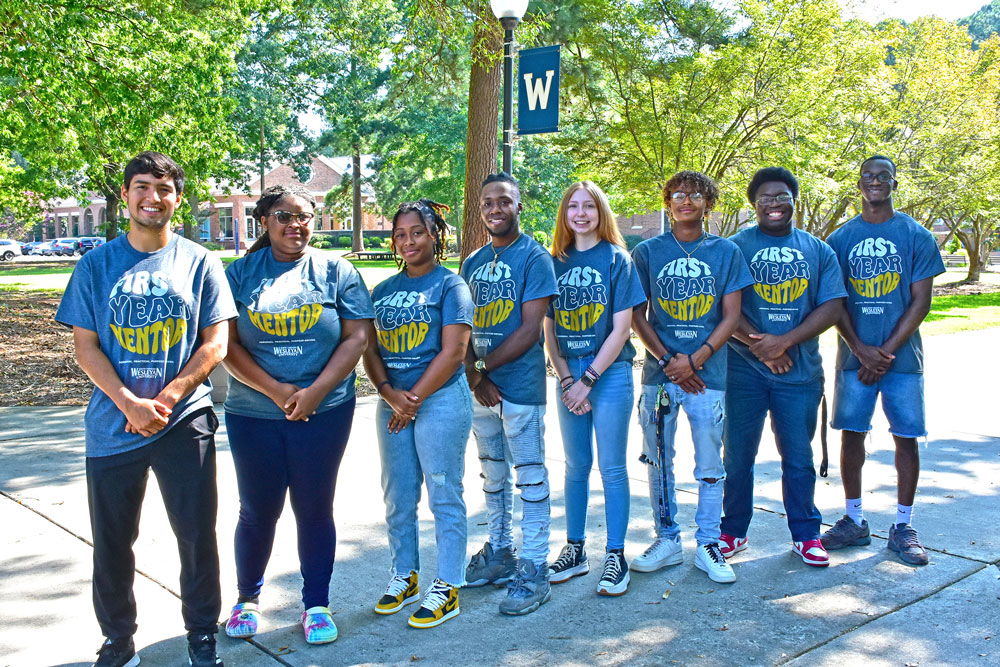 group of students standing in front of light pole