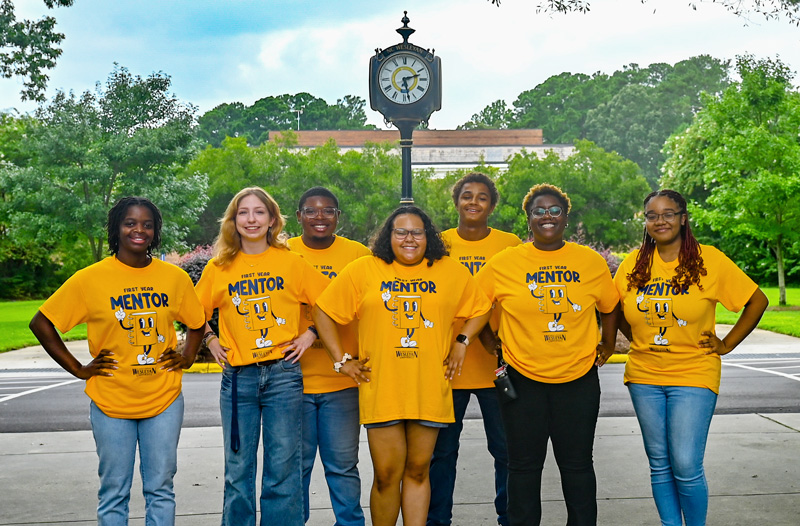 group of students standing in front of light pole