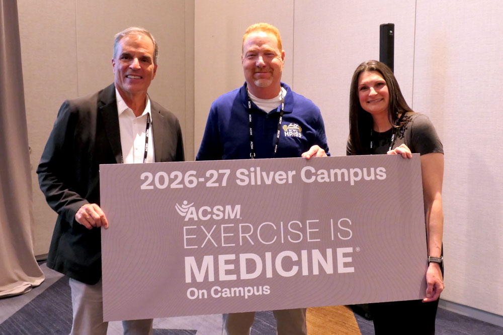 faculty memebers standing in front of exercise is medicine sign