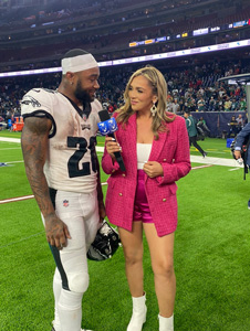 latin sports reporter on football field with player